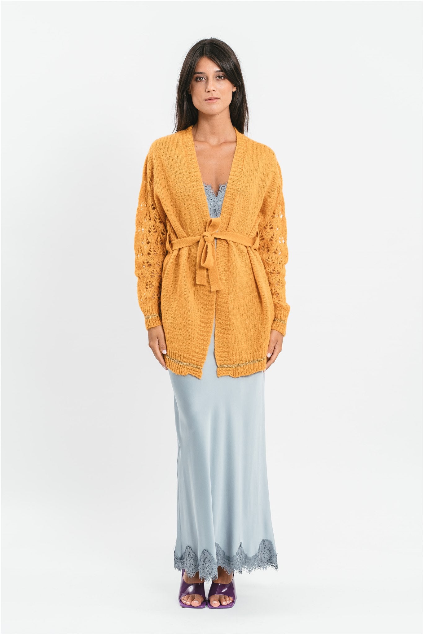 Modella indossa cardigan giallo ocra corto con maniche traforate. Frontale
