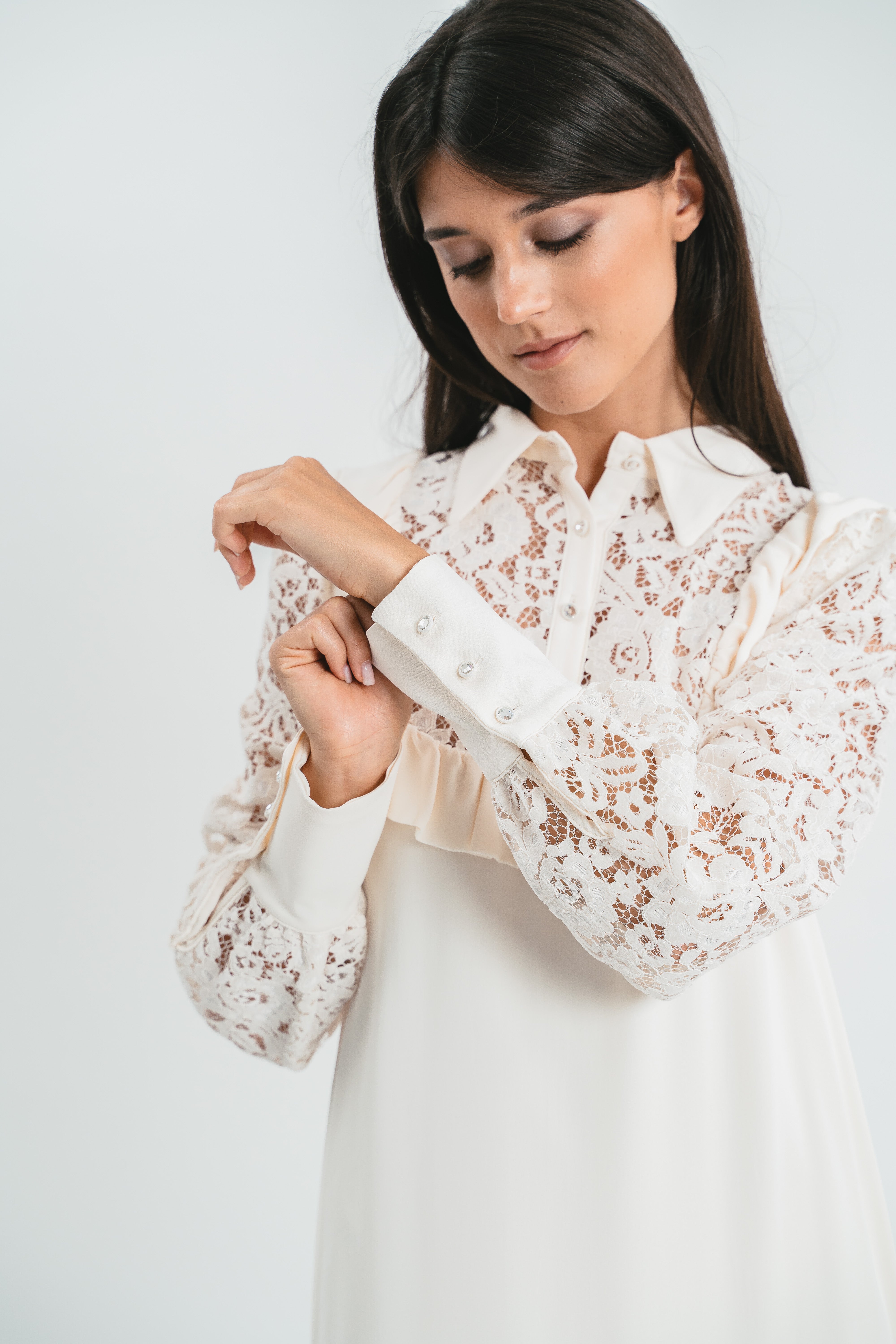 Modella indossa abito bianco corto con plastron di pizzo. Dettaglio