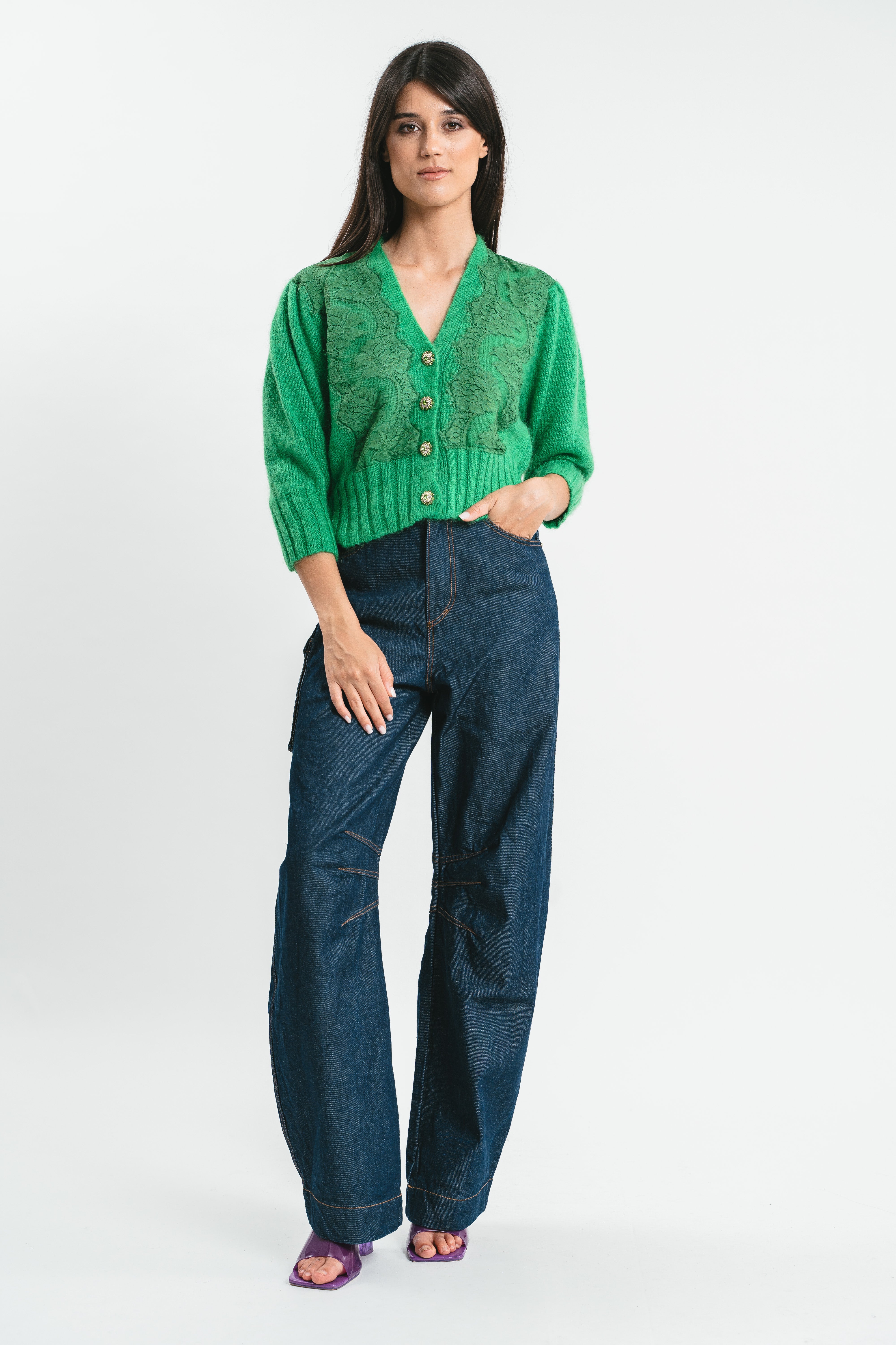Modella indossa cardigan crop verde con pizzo e bottoni.
Frontale