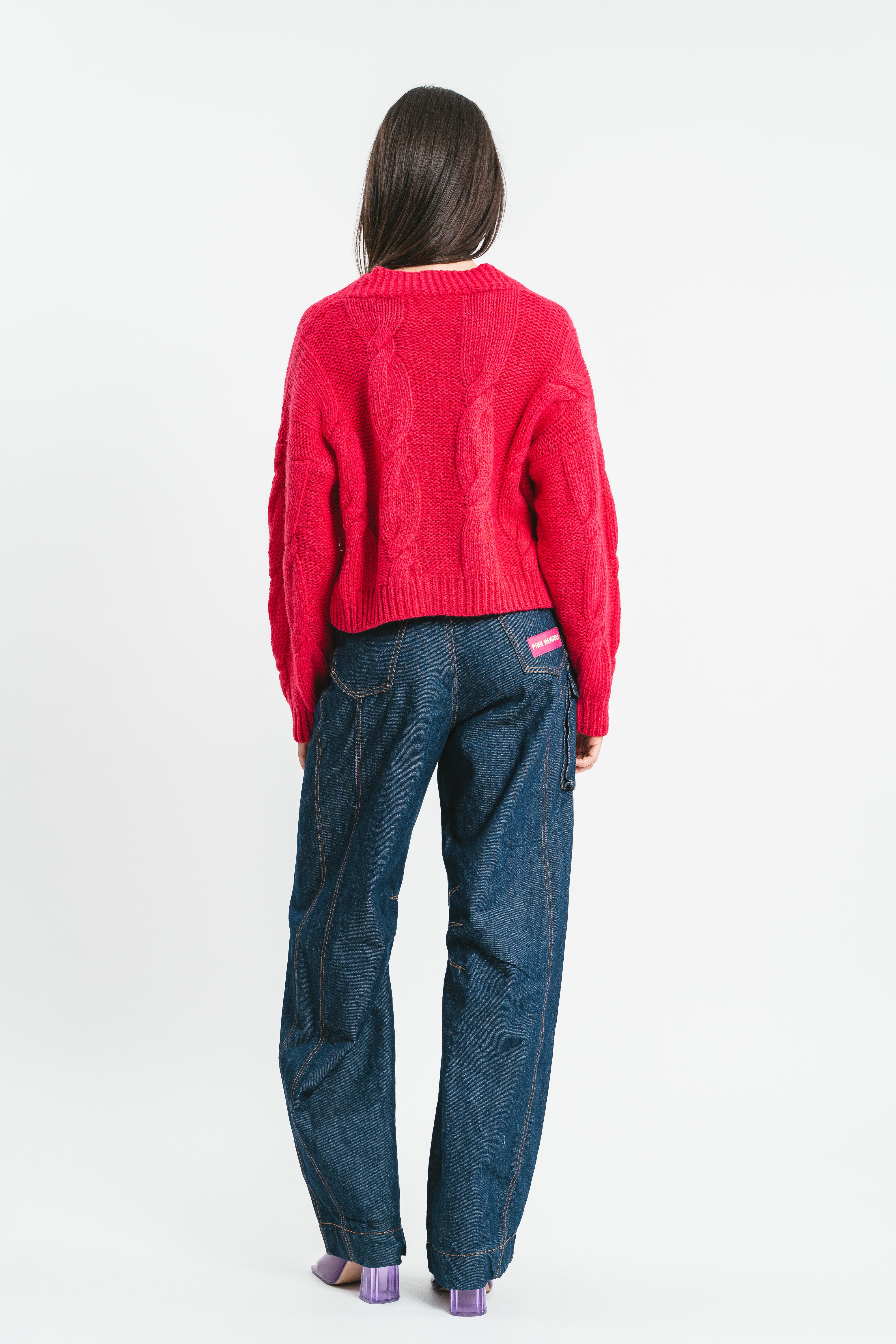 Modella indossa cardigan crop fucsia a trecce con bottone gioiello. Posteriore