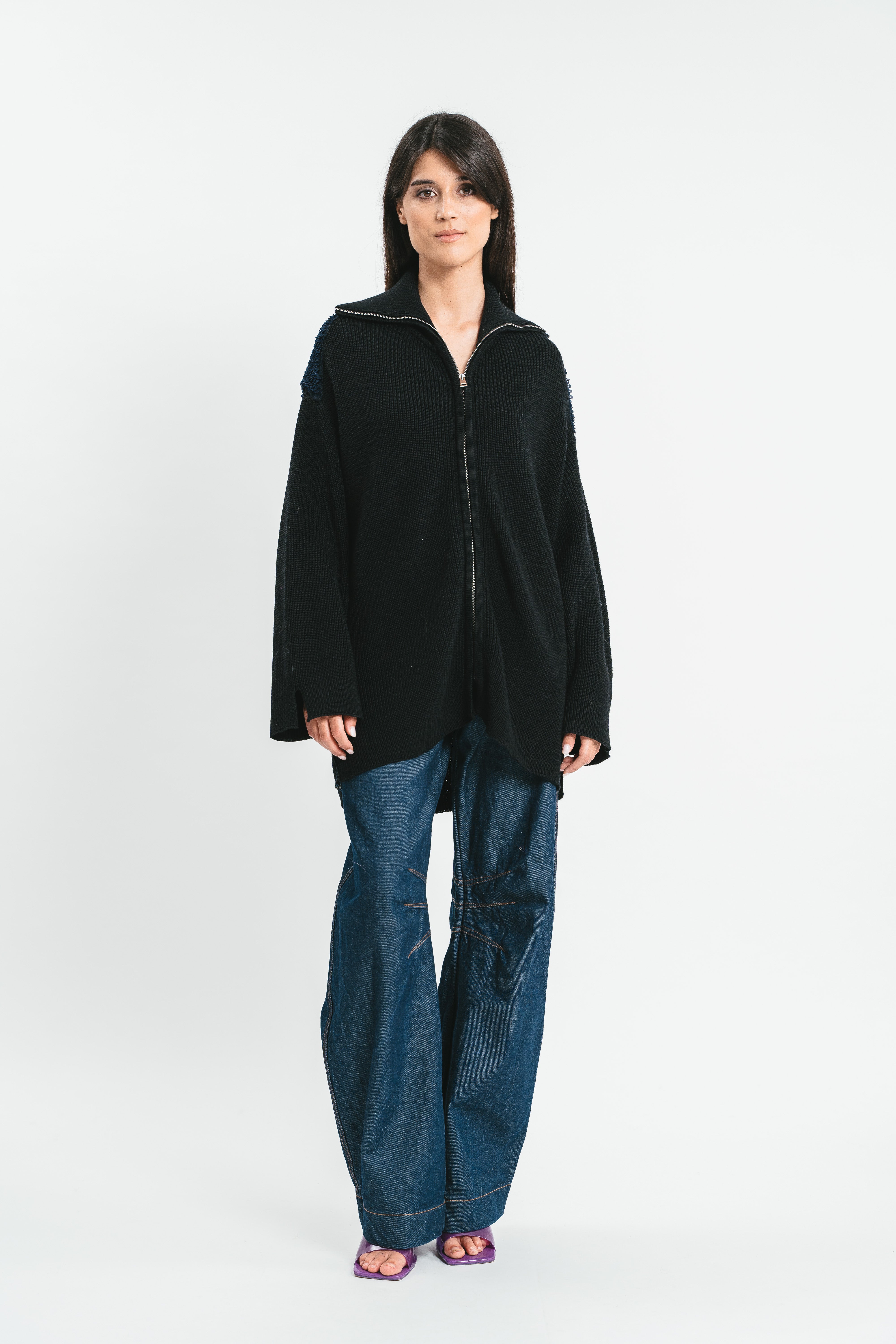 Modella indossa cardigan over nero con zip e colletto.
Frontale