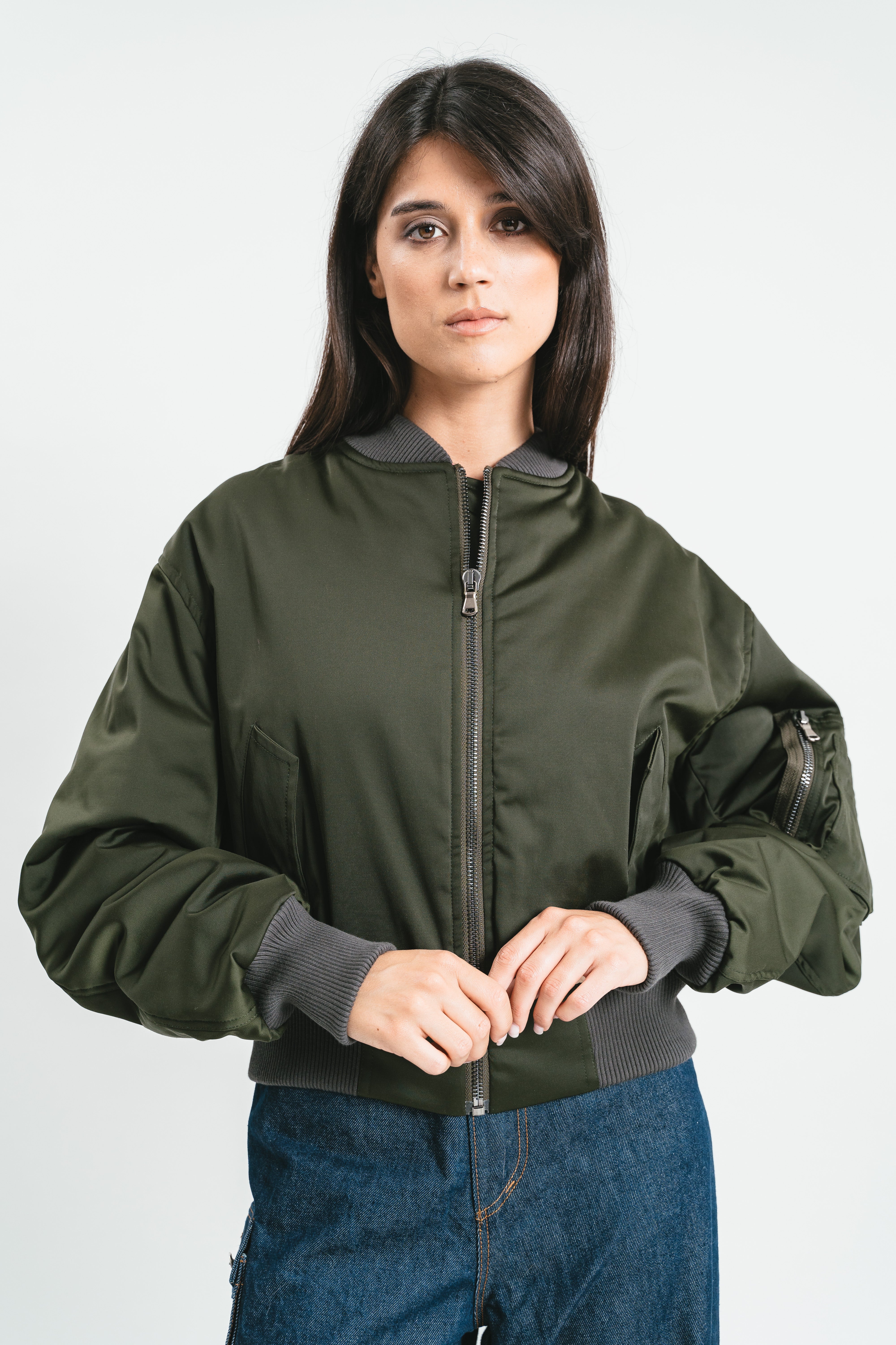 Modella indossa bomber verde militare corto con scritta strass. Dettaglio