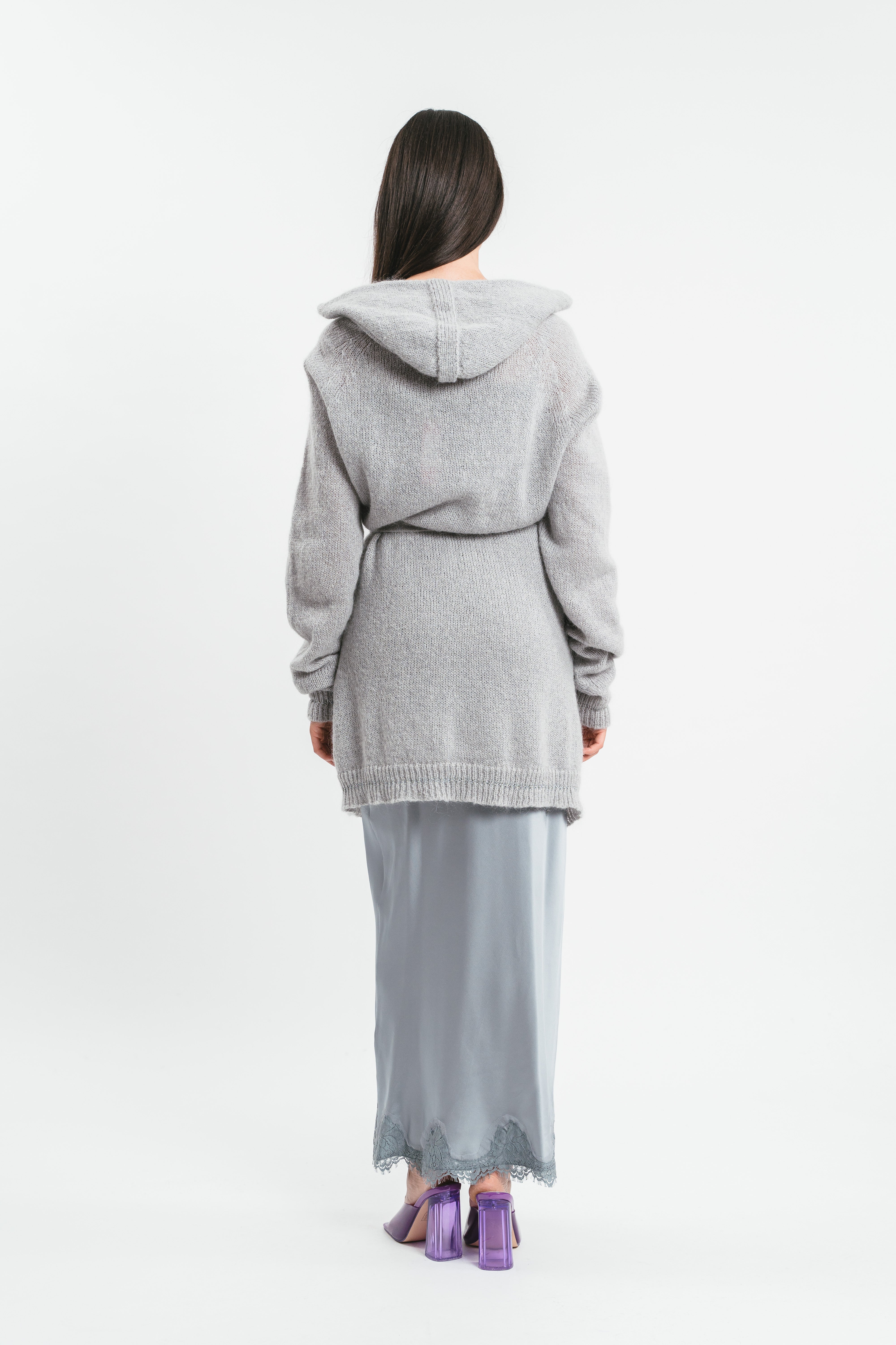Modella indossa cardigan grigio con cappuccio e maniche arricciate con cintura in coordinato. Posteriore