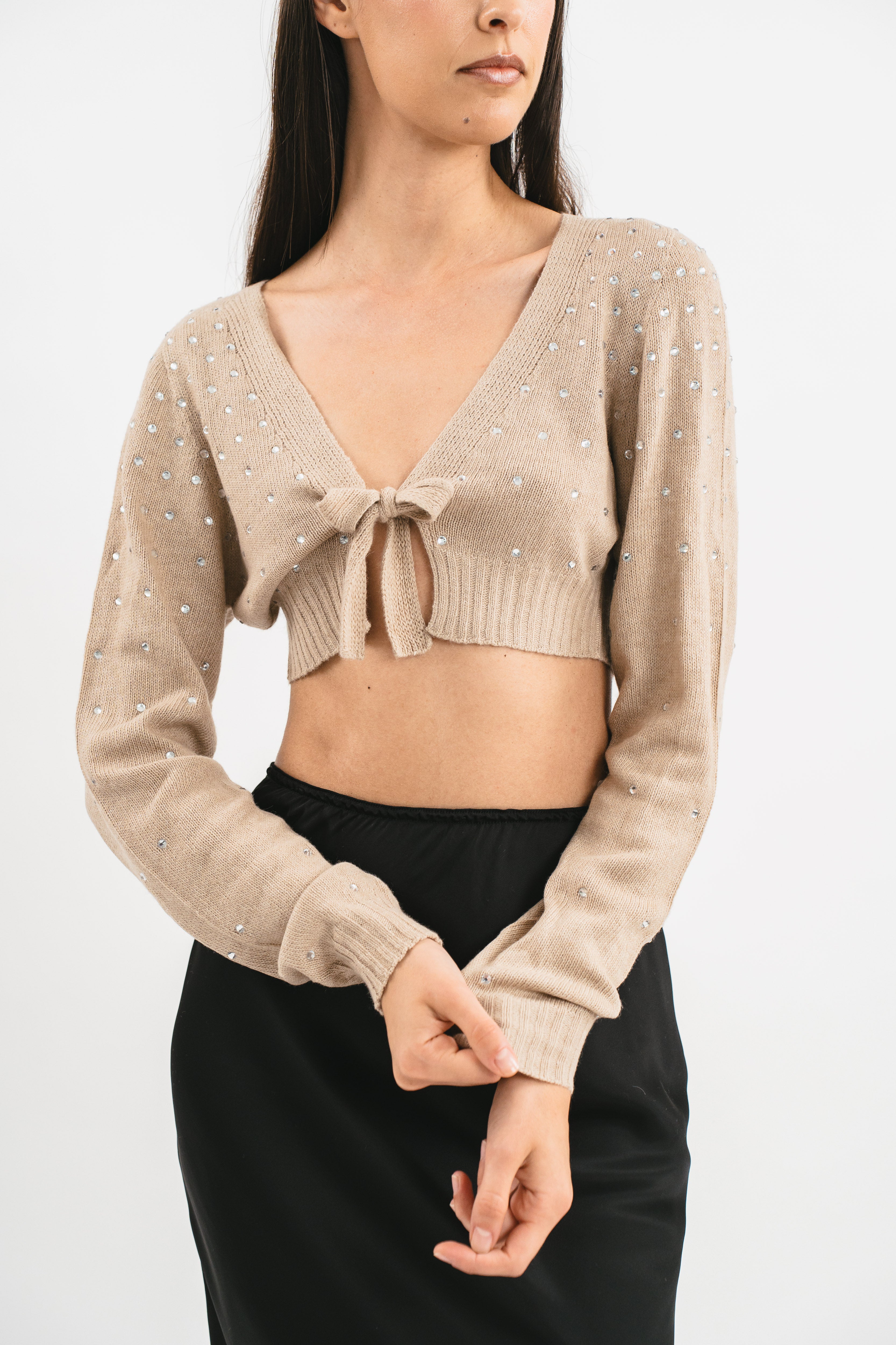 Modella indossa coprispalle beige crop con strass. Dettaglio