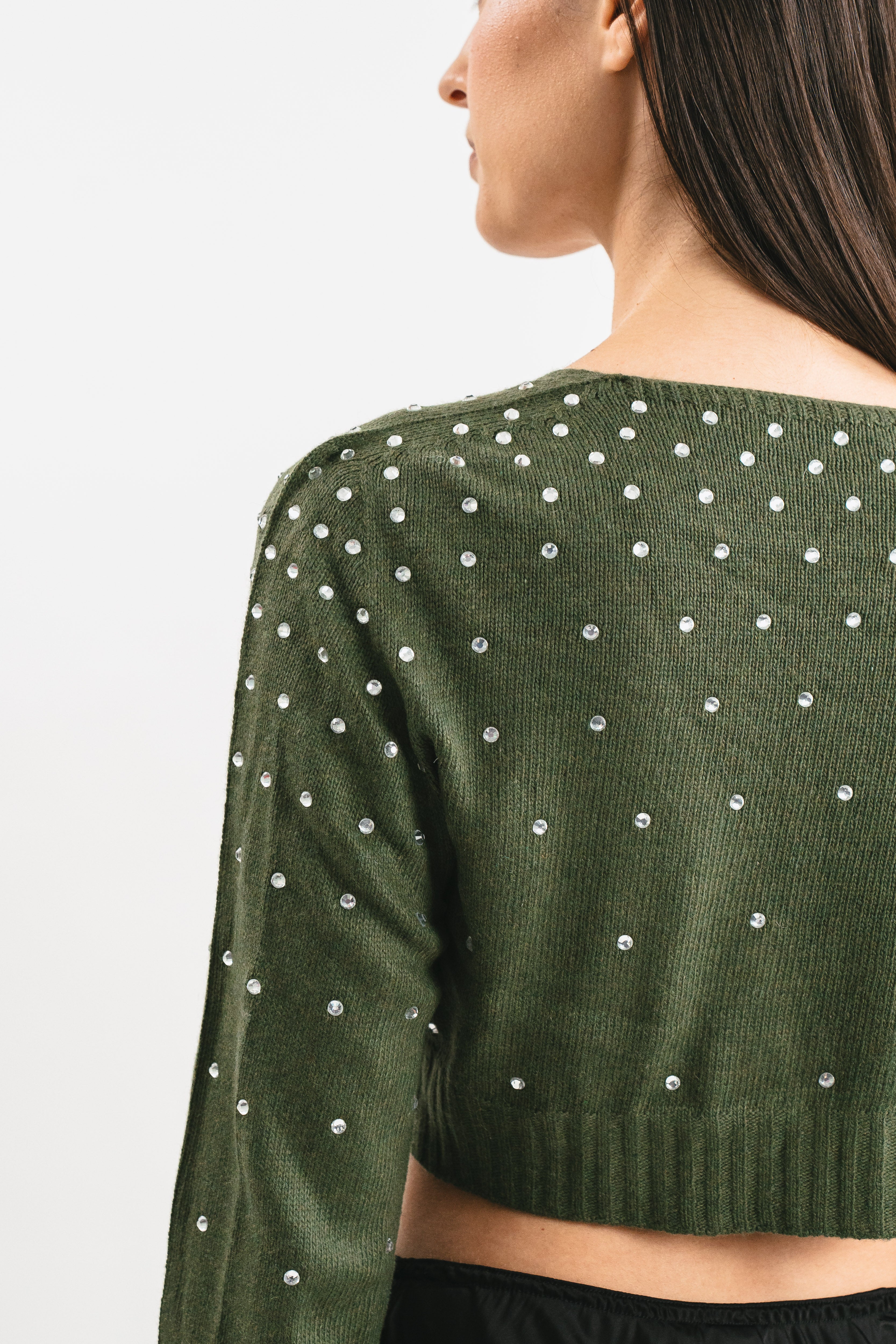 Modella indossa coprispalle verde militare crop con strass. Dettaglio