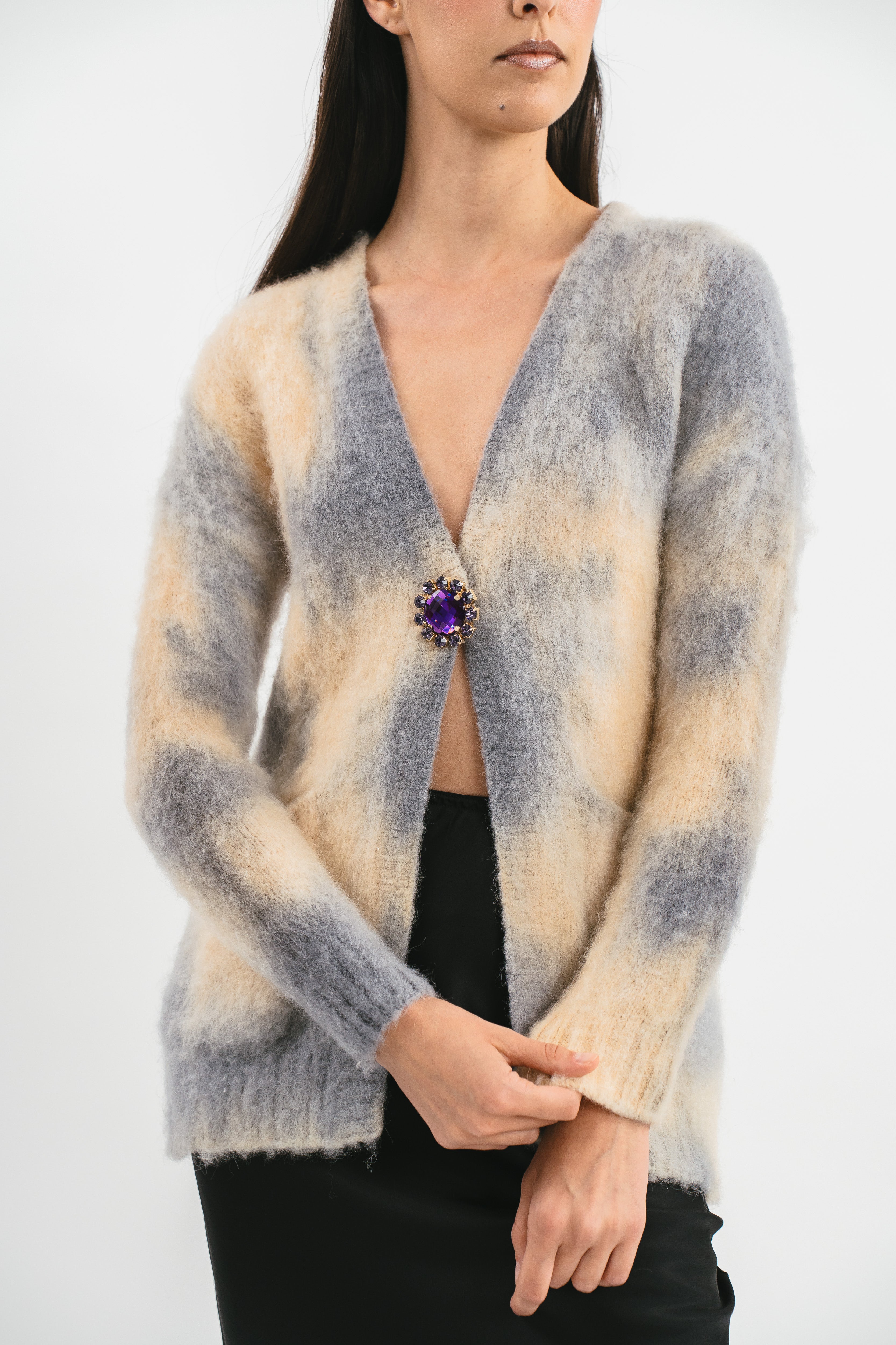 Modella indossa cardigan con tasche e bottoni. Dettaglio