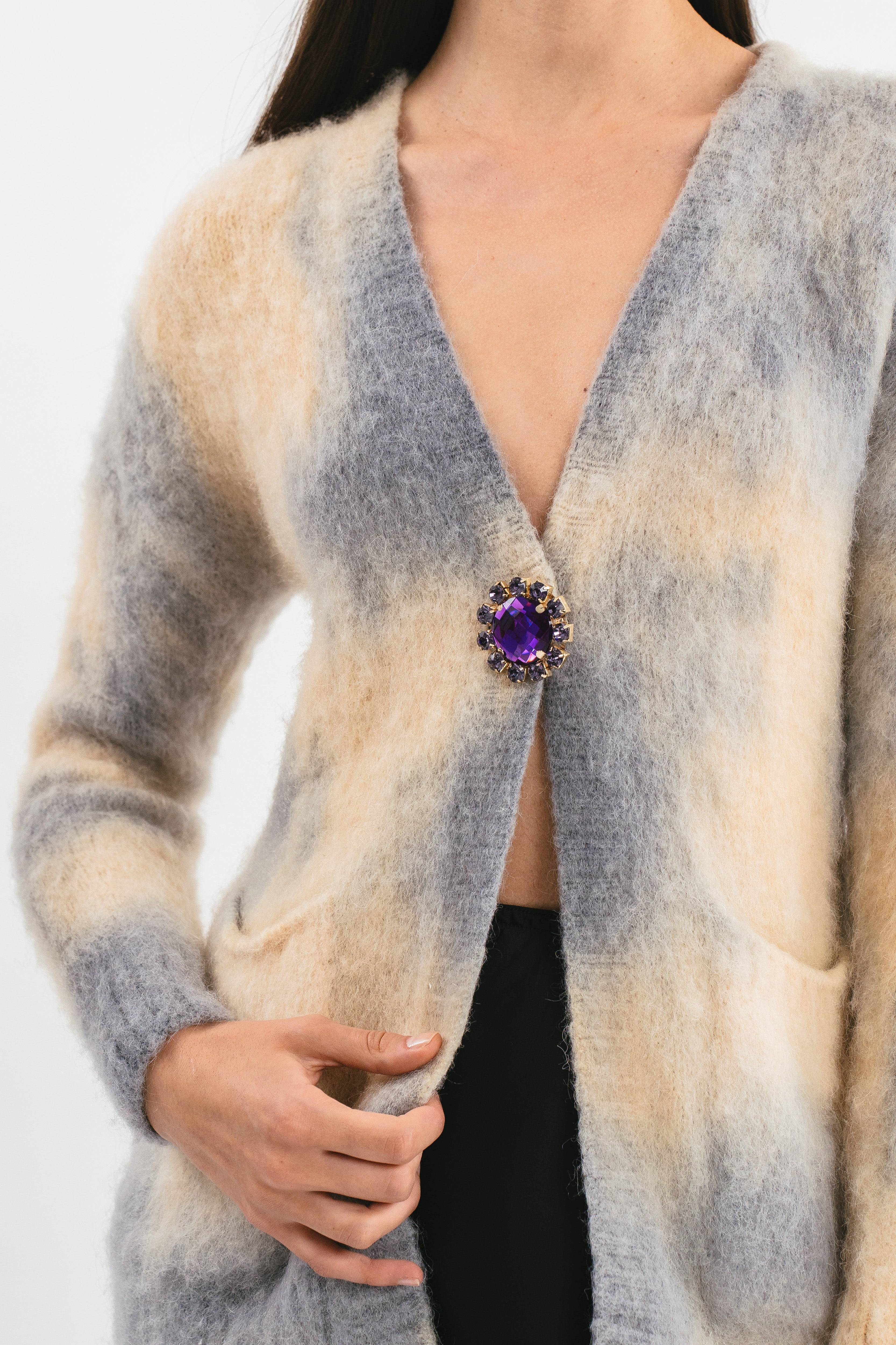 Modella indossa cardigan con tasche e bottoni. Dettaglio