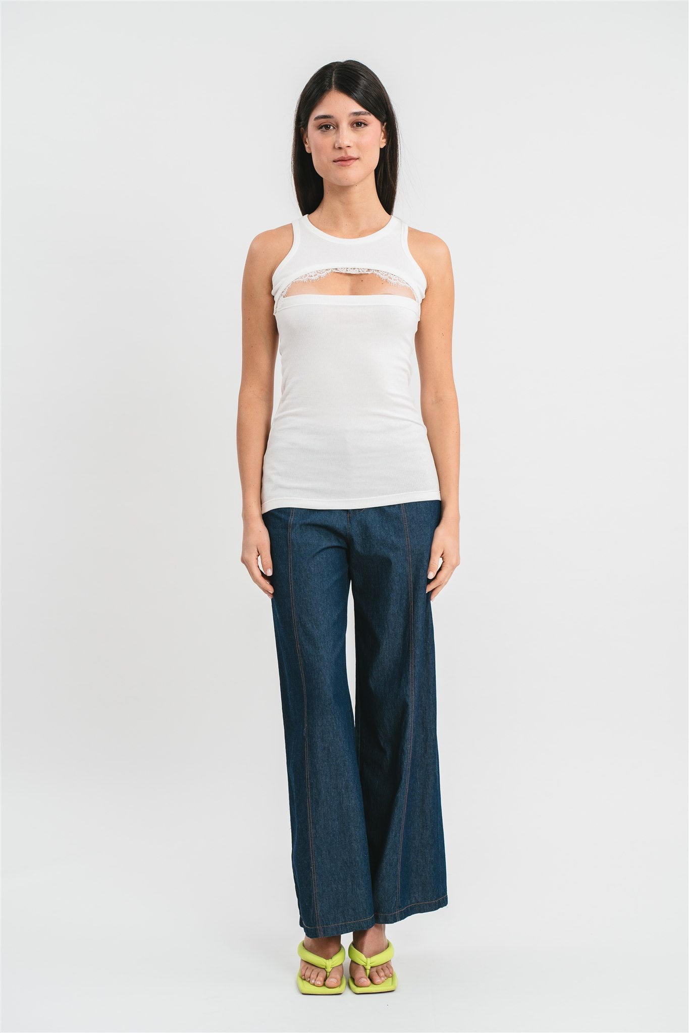 Modella indossa canotta bianca a costine con cut-out e dettagli in pizzo francese. Frontale