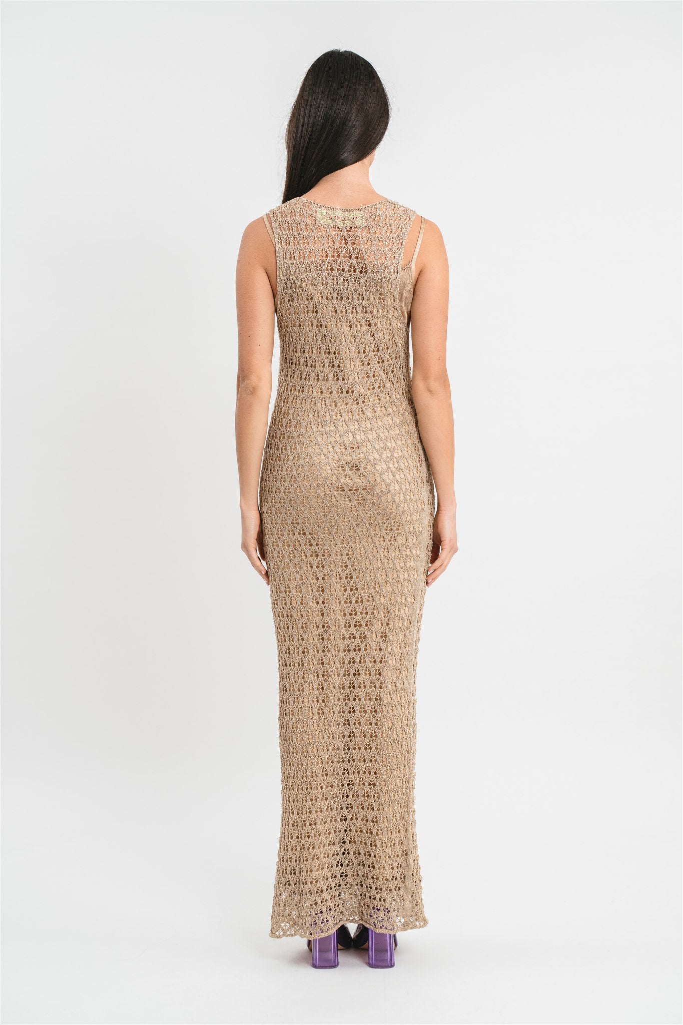 Modella indossa abito oro senza maniche traforato con filo lurex.
Retro