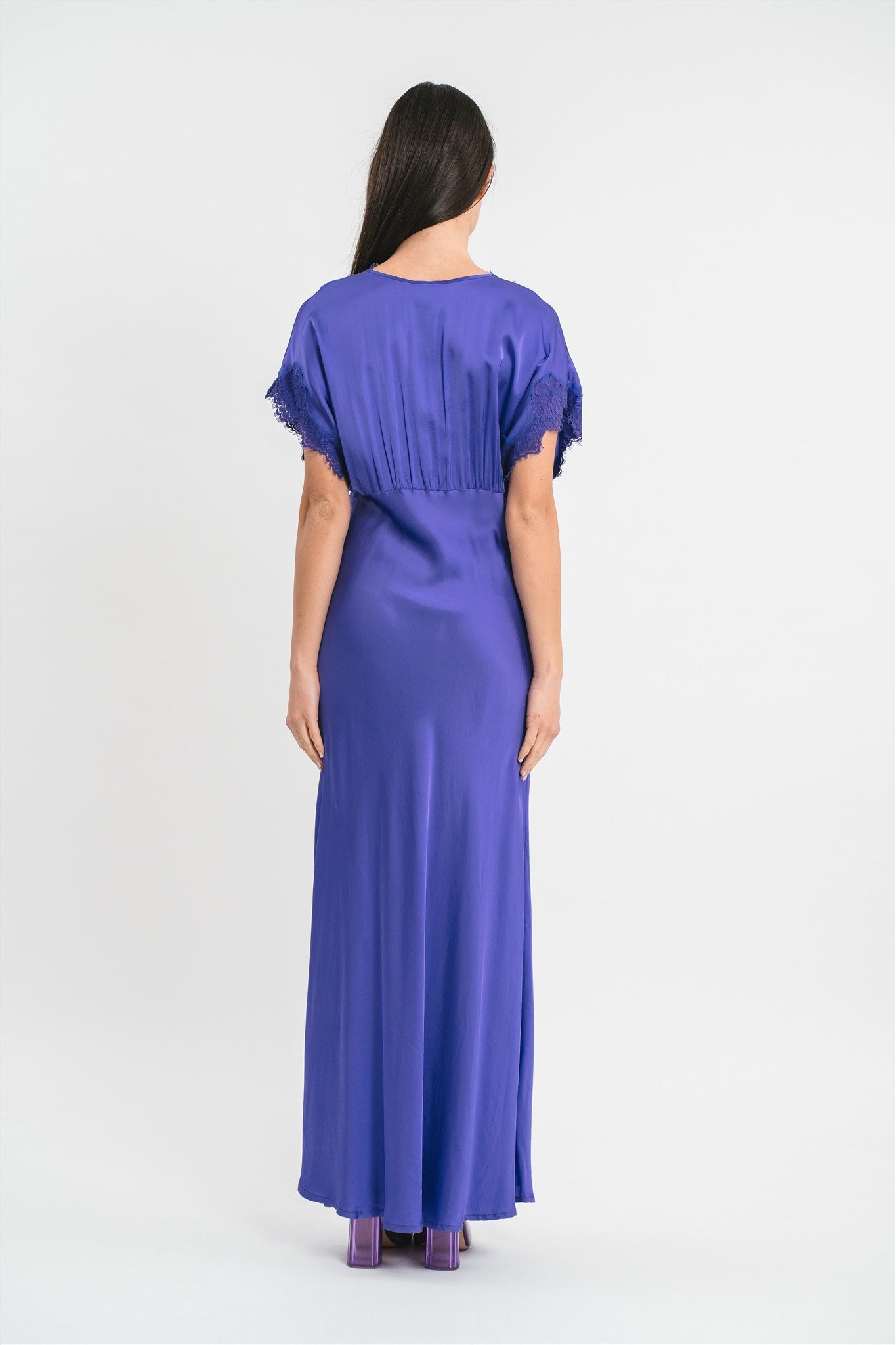 Modella indossa abito viola lungo in viscosa elasticizzata con rifiniture in pizzo francese. Retro