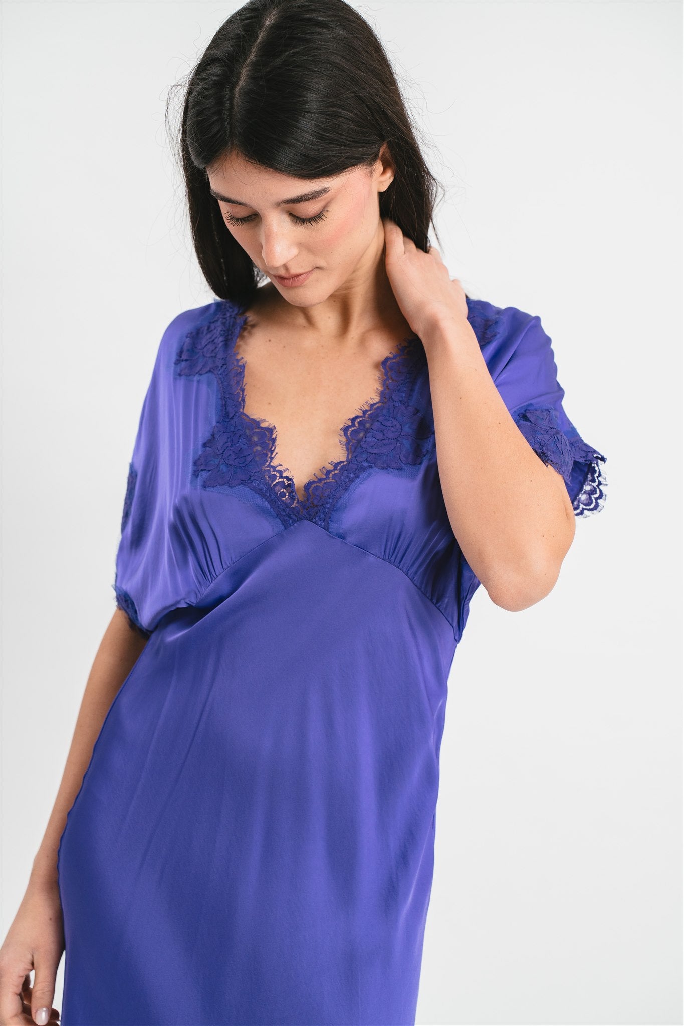 Modella indossa abito viola lungo in viscosa elasticizzata con rifiniture in pizzo francese. Dettaglio