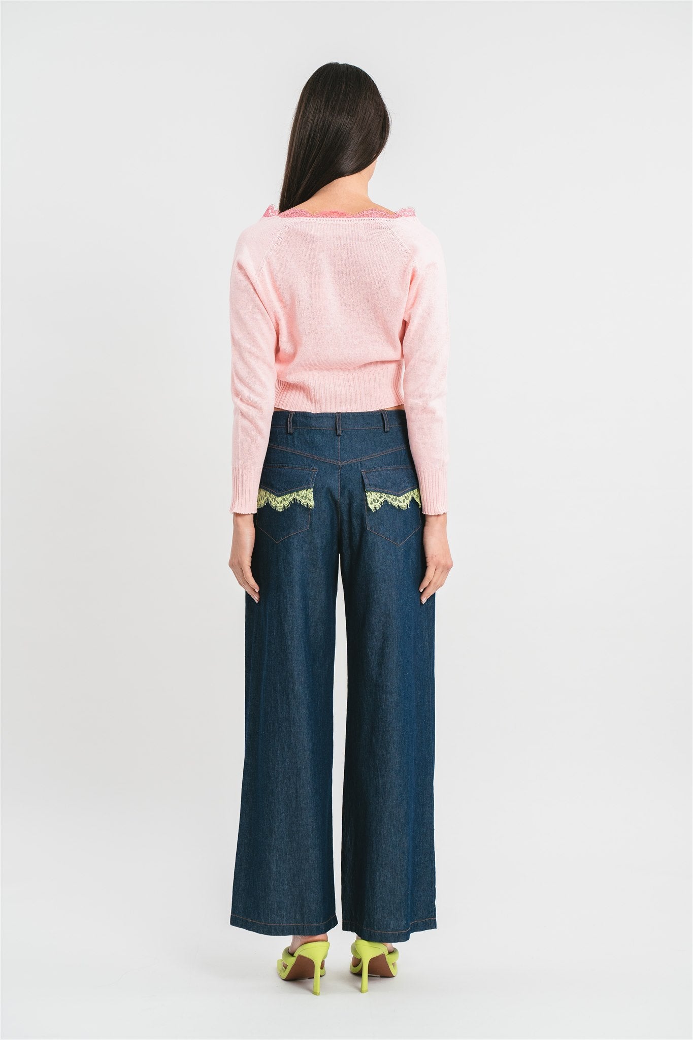 Modella indossa cardigan rosa crop con dettagli in pizzo. Posteriore