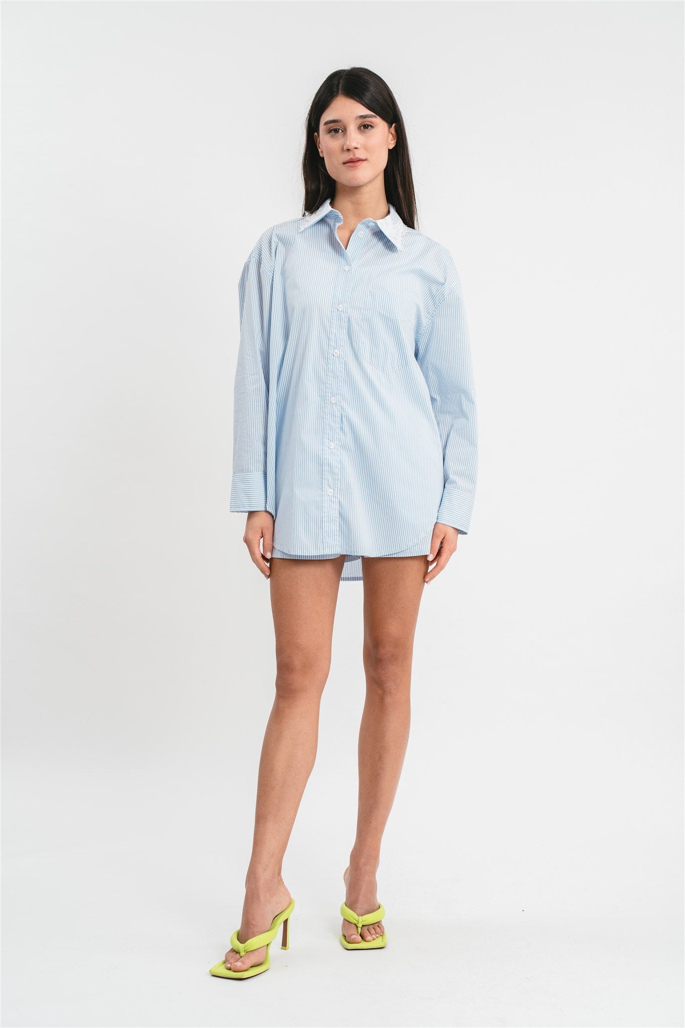 Modella indossa camicia celeste a righe con dettagli in pizzo. Frontale