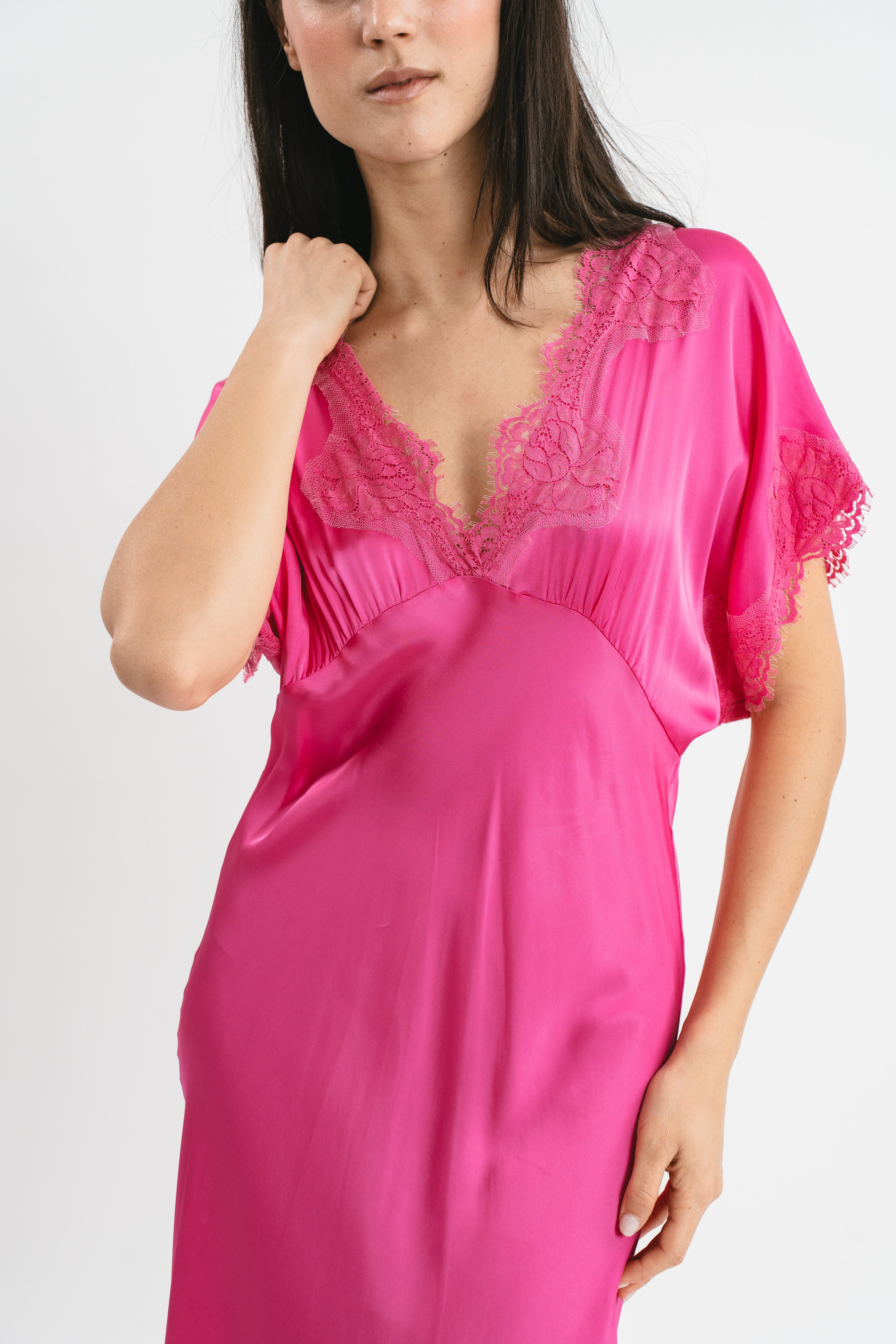 Modella indossa abito fuxia lungo in viscosa elasticizzata con rifiniture in pizzo francese. Dettaglio