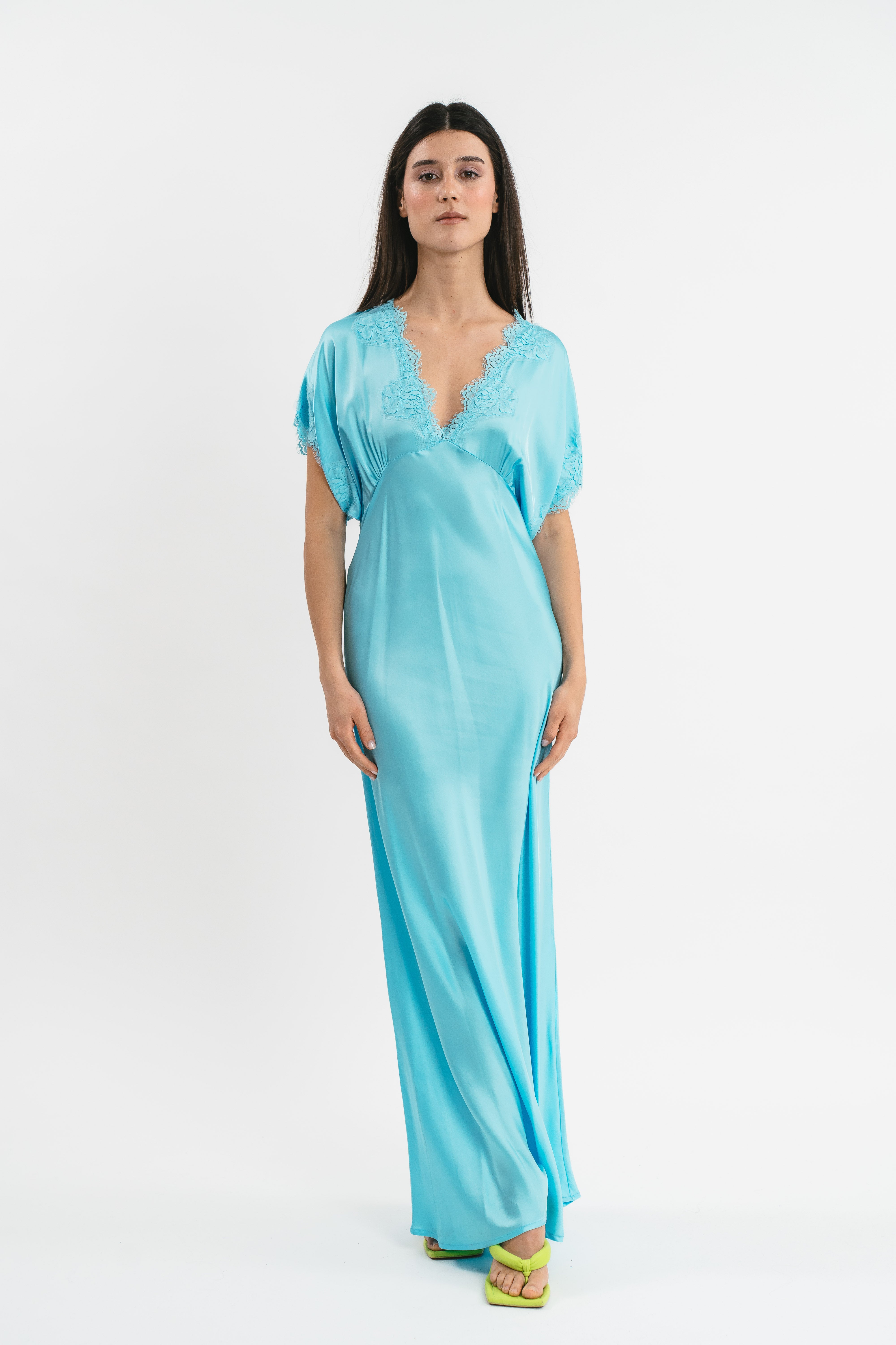 Modella indossa abito color cielo lungo in viscosa elasticizzata con rifiniture in pizzo francese. Frontale