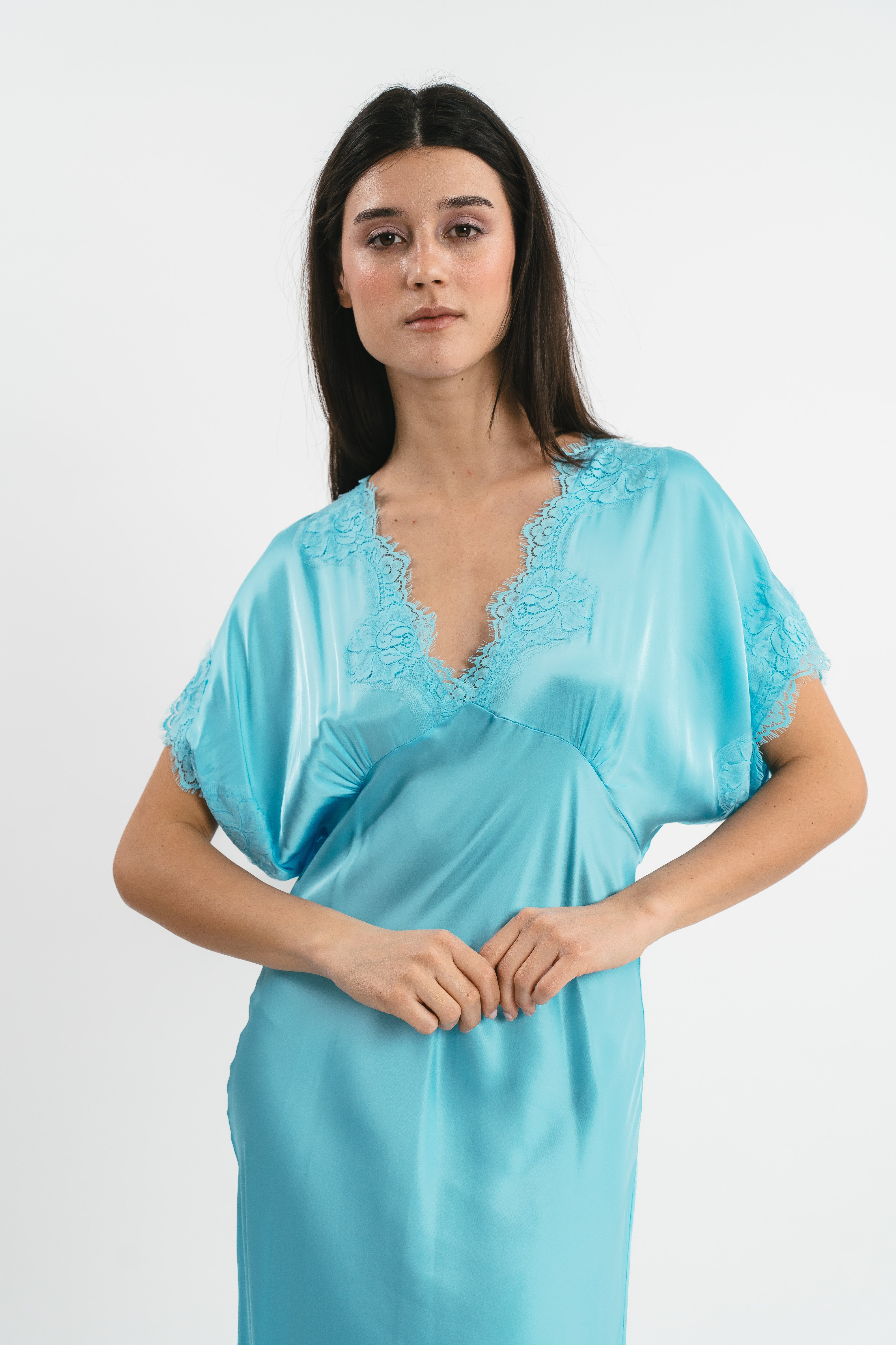 Modella indossa abito color cielo lungo in viscosa elasticizzata con rifiniture in pizzo francese. Dettaglio