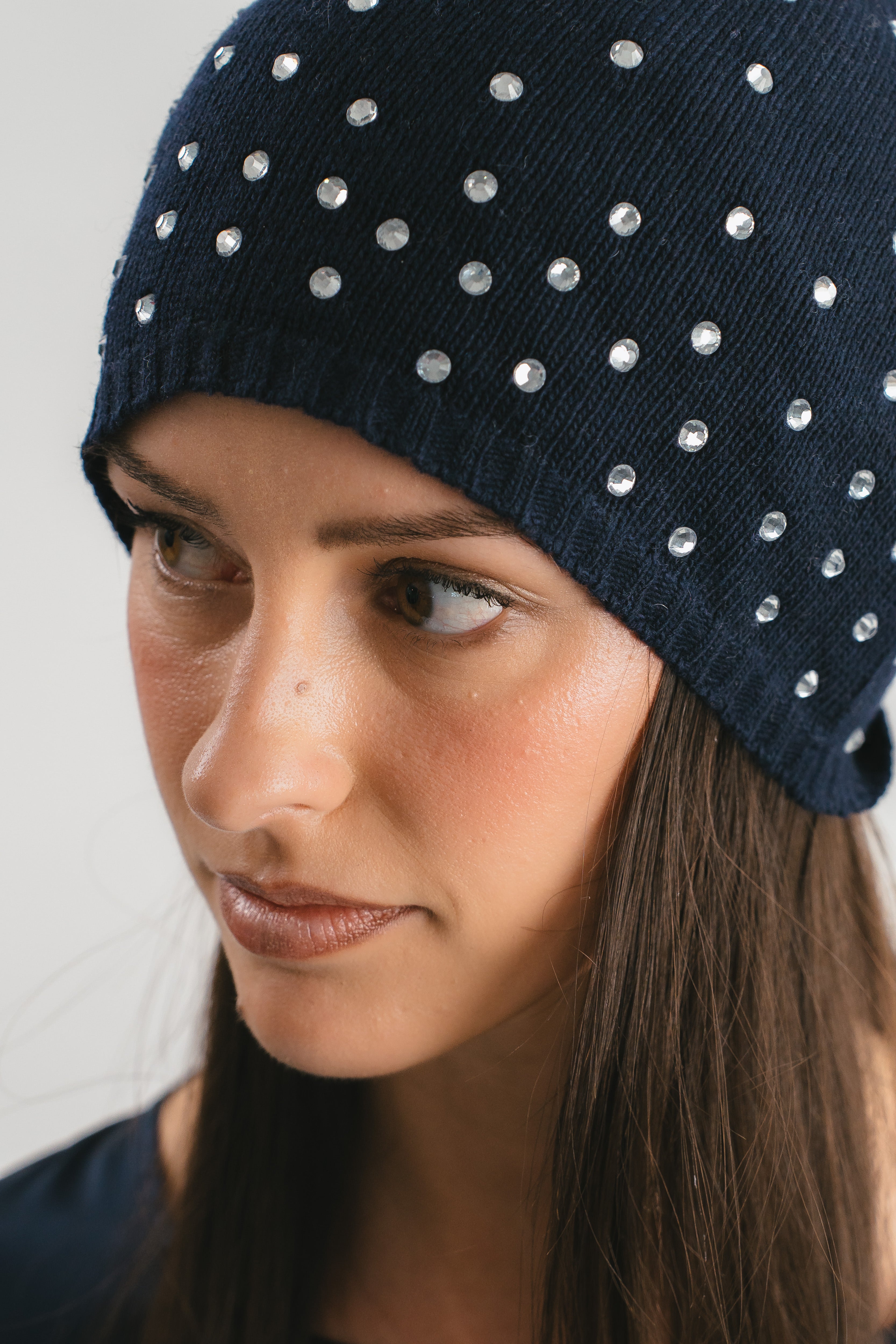 Modella indossa cappello blu con strass. Dettaglio