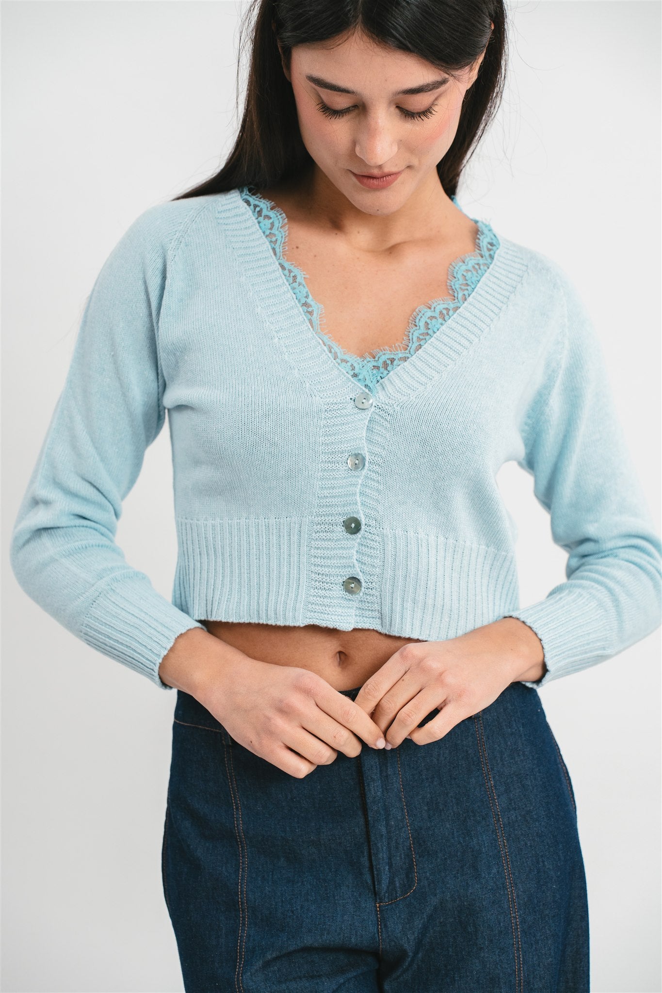 Modella indossa cardigan celeste crop con dettagli in pizzo. Dettaglio