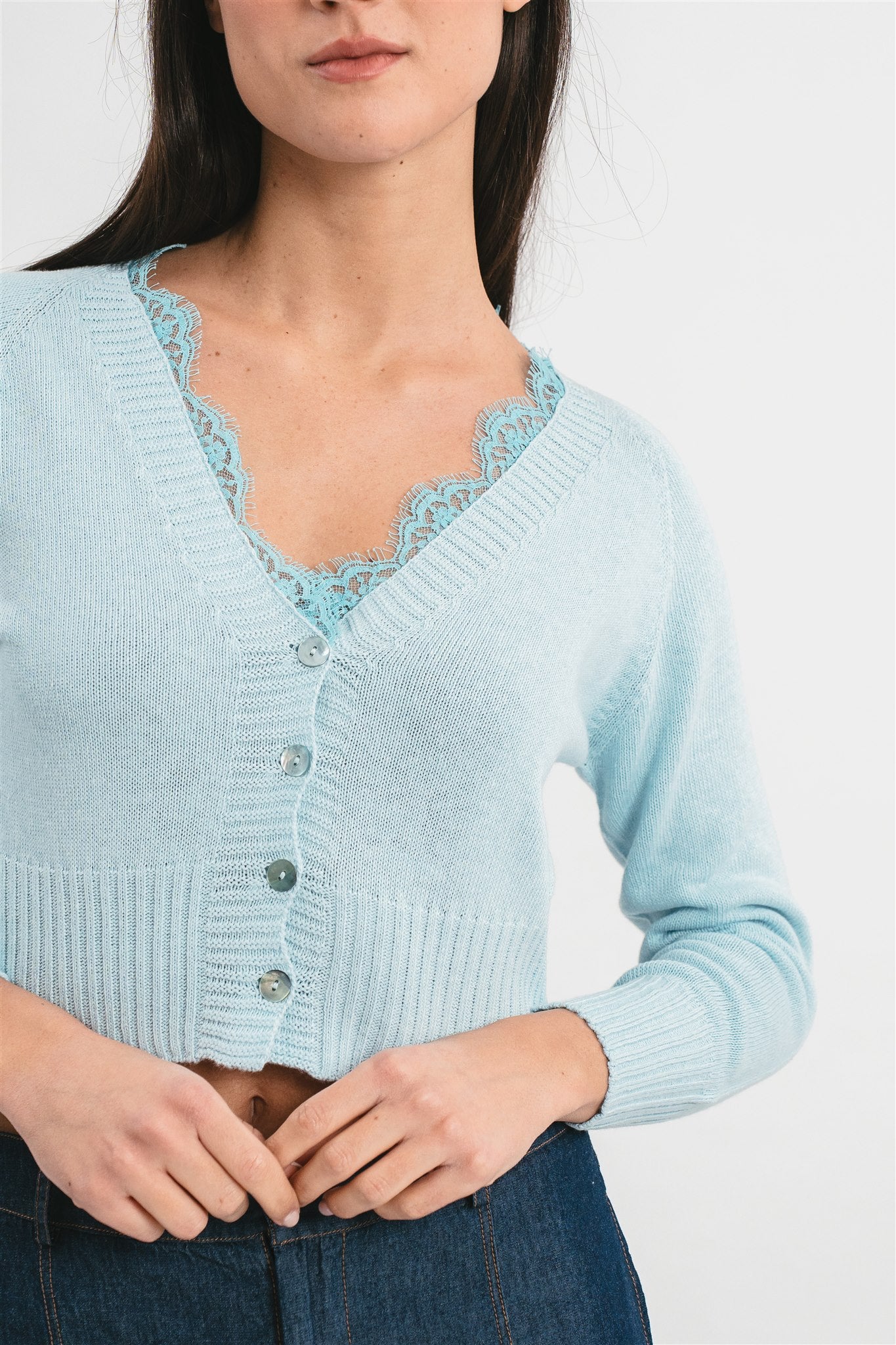 Modella indossa cardigan celeste crop con dettagli in pizzo. 
Dettaglio