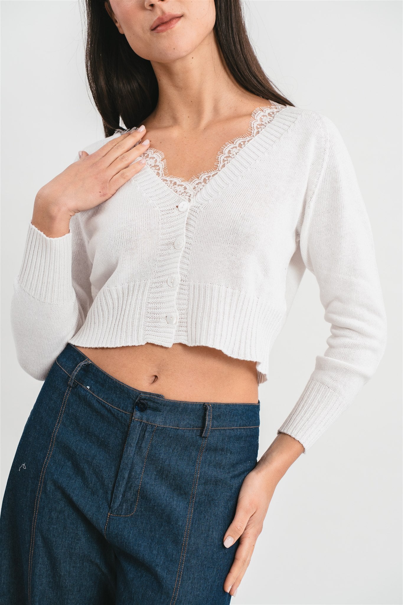 Modella indossa cardigan bianco crop con dettagli in pizzo. Dettaglio