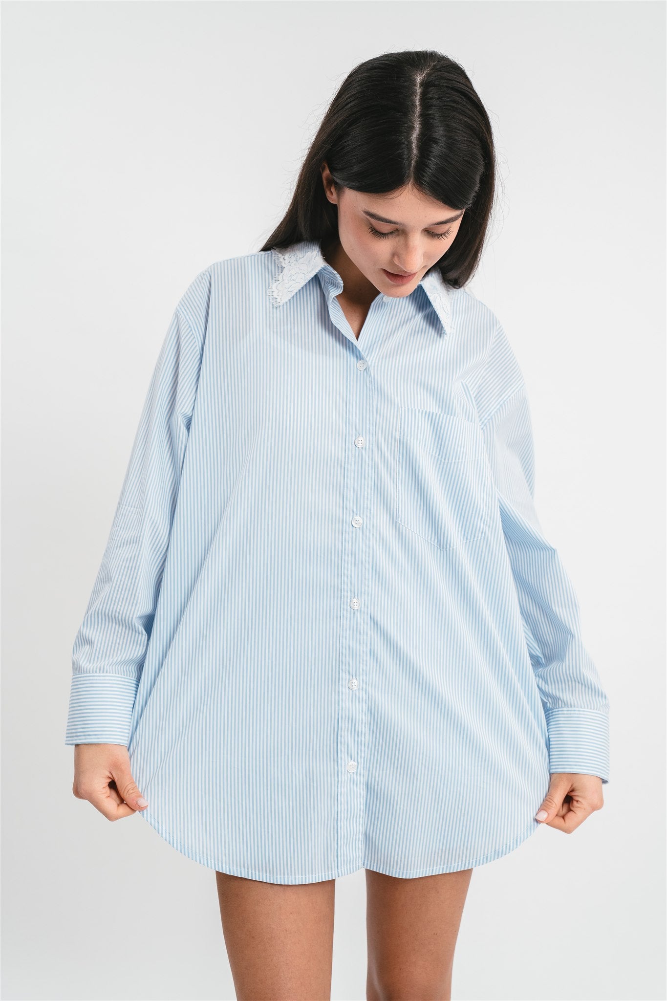 Modella indossa camicia celeste a righe con dettagli in pizzo. Dettaglio